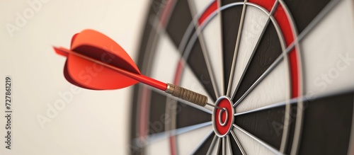 Close up shot red darts arrows in the target of dartboard center on dark blue sky background. Business target or goal success and winner concept.