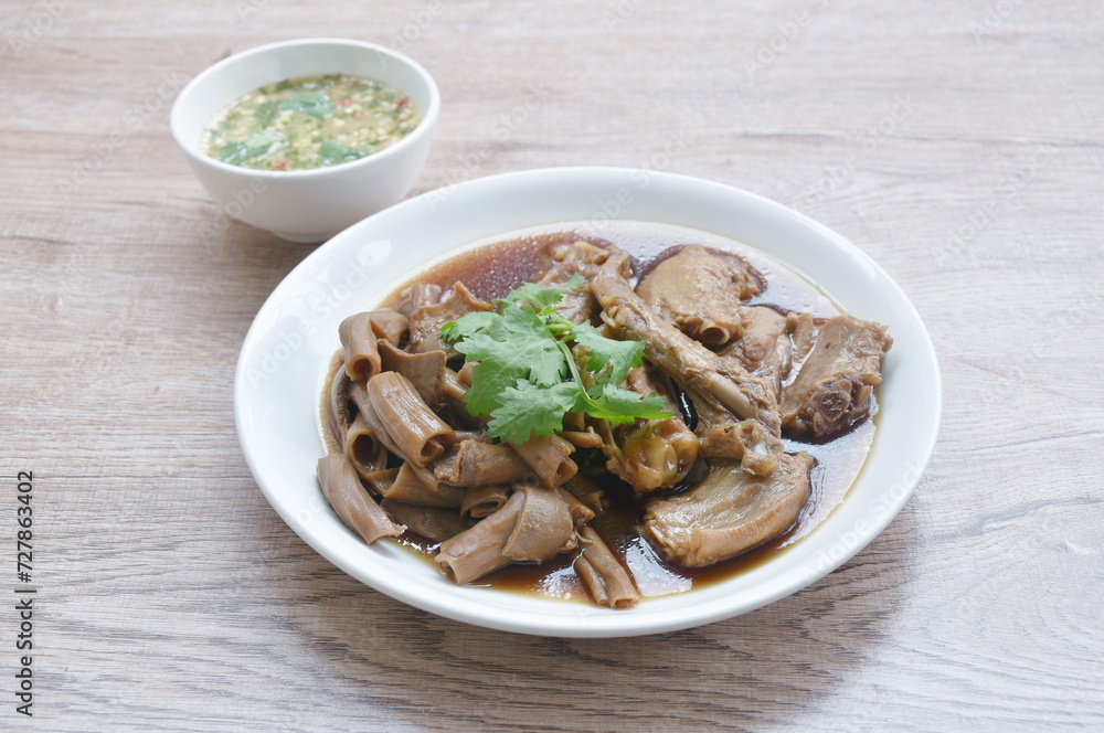 chop boiled duck wing and stew intestine in brown soy soup on plate dipping spicy sauce chop boiled duck wing and stew intestine in brown soy soup on plate dipping spicy sauce