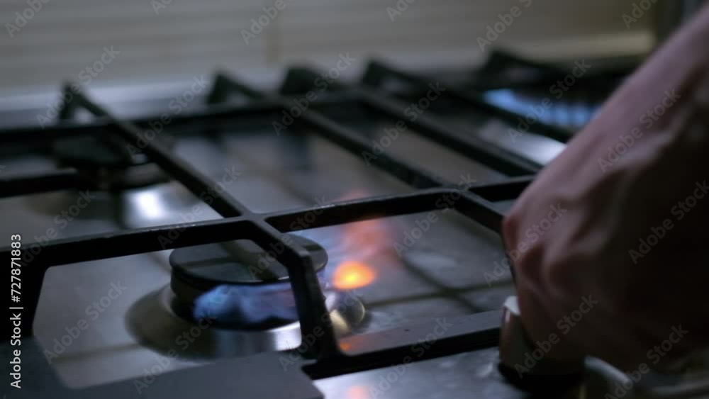 Person hand turns on kitchen cooktop gas burner and natural gas ignites burns with blue flame and then turned off. Person hand turns on kitchen cooktop gas burner and natural gas ignites burns with blue flame and then turned off.