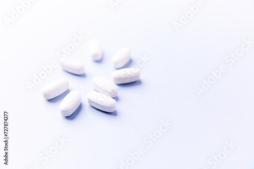 Amino acids tablets. Nutrition for bodybuilding. Fitness supplements on bright paper background. Soft focus. Copy space. 