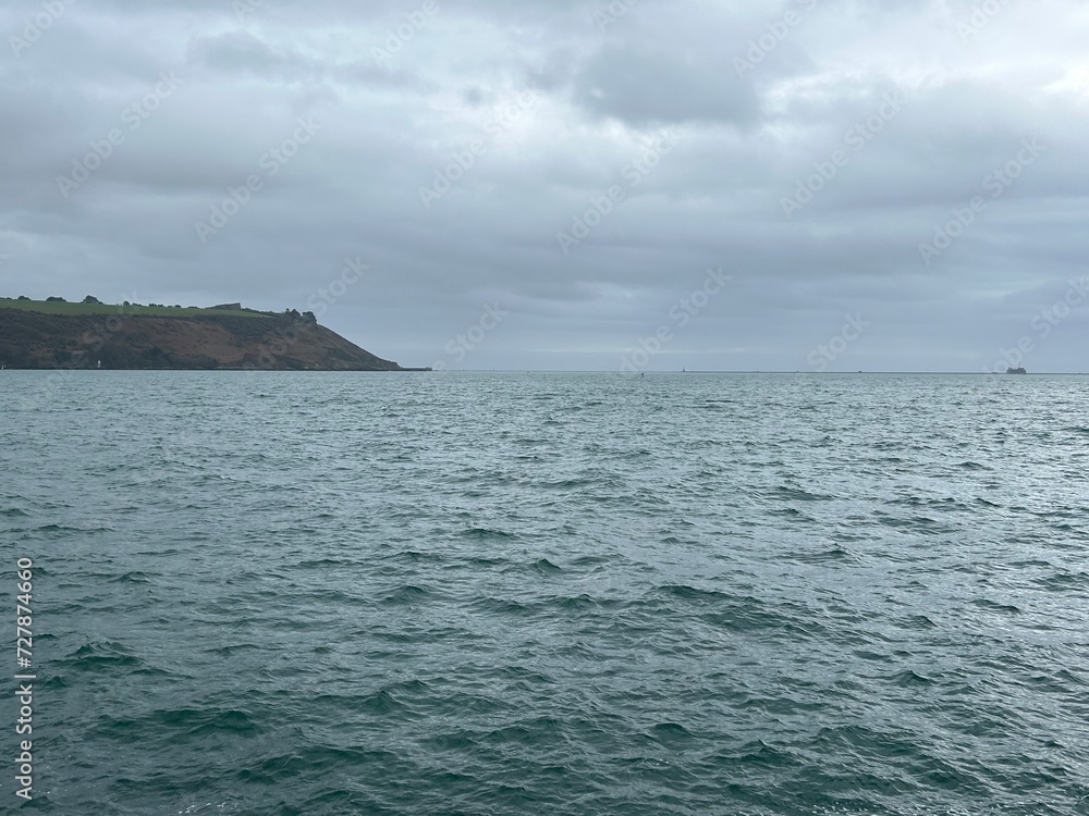 Plymouth sound sea on a grey winters day with sailing yacht in the United Kingdom. 