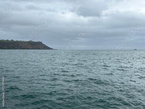 Plymouth sound sea on a grey winters day with sailing yacht in the United Kingdom.  © Kerrygerdes