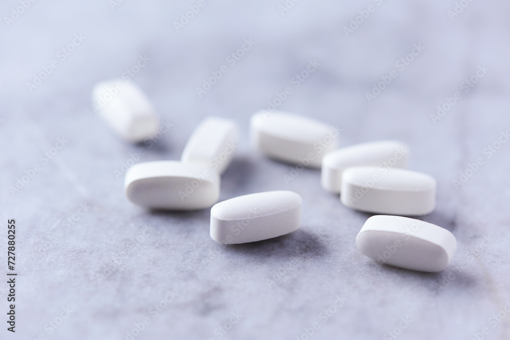Lysine tablets. Concept for a healthy dietary supplementation. Nervous System Support. Bright stone background. Close up. Copy space. Lysine tablets. Concept for a healthy dietary supplementation. Nervous System Support. Bright stone background. Close up. Copy space.