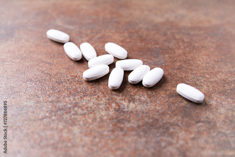 White tablets on stone background. Soft focus. Close up. Copy space.