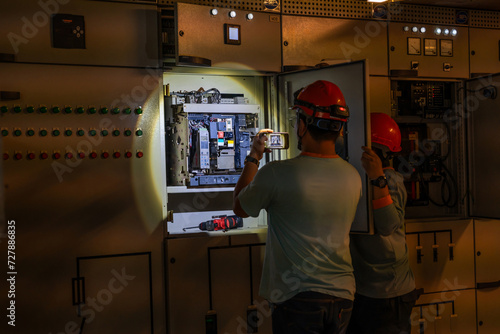 Engineers or technicians check electrical equipment while electricity is running out. photo