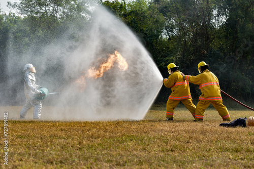 Firefighters demonstrate how to use a fire hose to extinguish a fire.