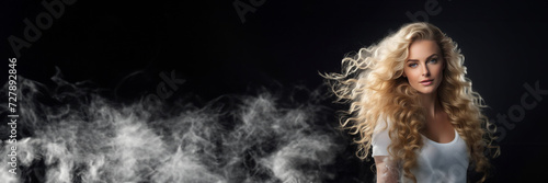 Beautiful blond girl with evening haircut form of waves and bright makeup isolated on black background with smoke effect. Beauty face. Copy space banner with a place for text
