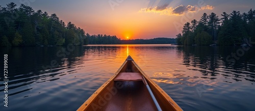 Photo a boat on a lake with the sun setting behind it © Sukhwinder