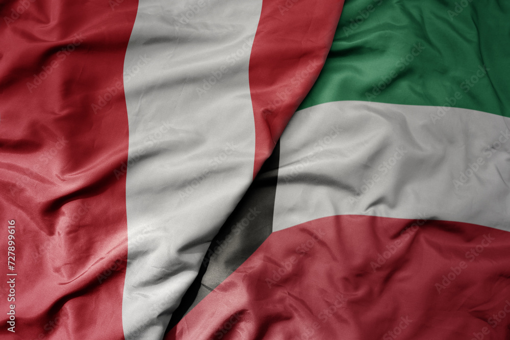 big waving national colorful flag of kuwait and national flag of peru .