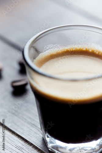 Coffee in glass cup on dark wooden background. Close up.
