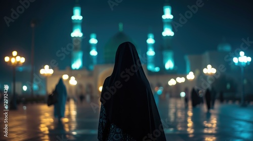 A Muslim woman in a niqab walking towards a big mosque, her figure silhouetted against the evening lights, back view
