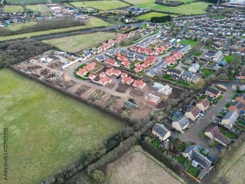 Drone view of a large housing development of detached bungalows in the East of England. Seen near a busy road bypass.