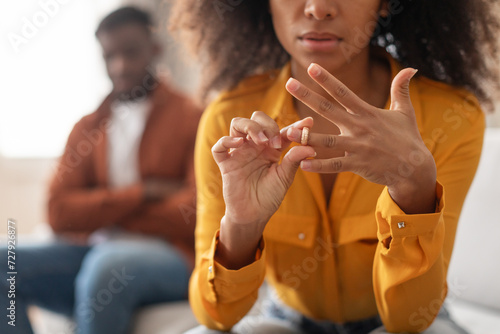 Fotografie black woman taking off wedding ring sitting near husband indoors