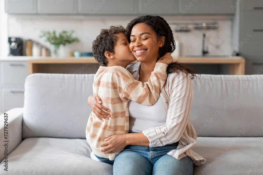 Mother's Day Concept. Black Little Boy Kissing His Mom In Cheek