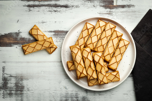 Sfogliatine, an Italian puff pastry with glaze on a plate on white background, top view photo