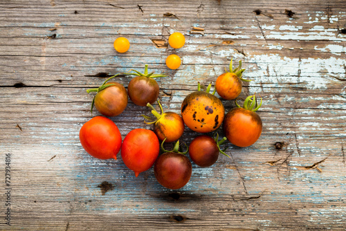Canvas Print Different colourful varieties of tomatoes on a vintage rustic wooden board top v