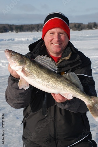 Ice angler with a walleye caught on a tip-up. 