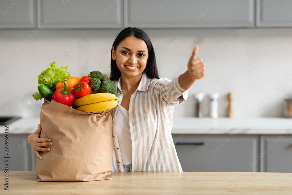 Happy young hindu woman with paper bag full of grocery - obrazy, fototapety, plakaty 