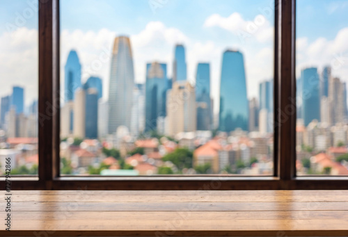 view of the city from a window with a wooden shelf