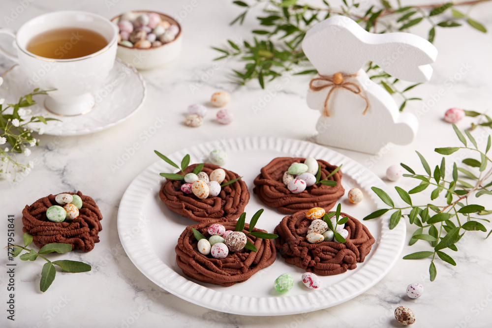 Easter chocolate shortbread cookies in a shape of nest filled with colorful egg candies. Delicious homemade festive food. Selective focus. Easter chocolate shortbread cookies in a shape of nest filled with colorful egg candies. Delicious homemade festive food. Selective focus.
