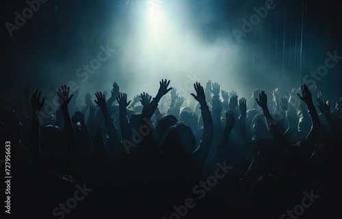 people in a concert with their hands raised