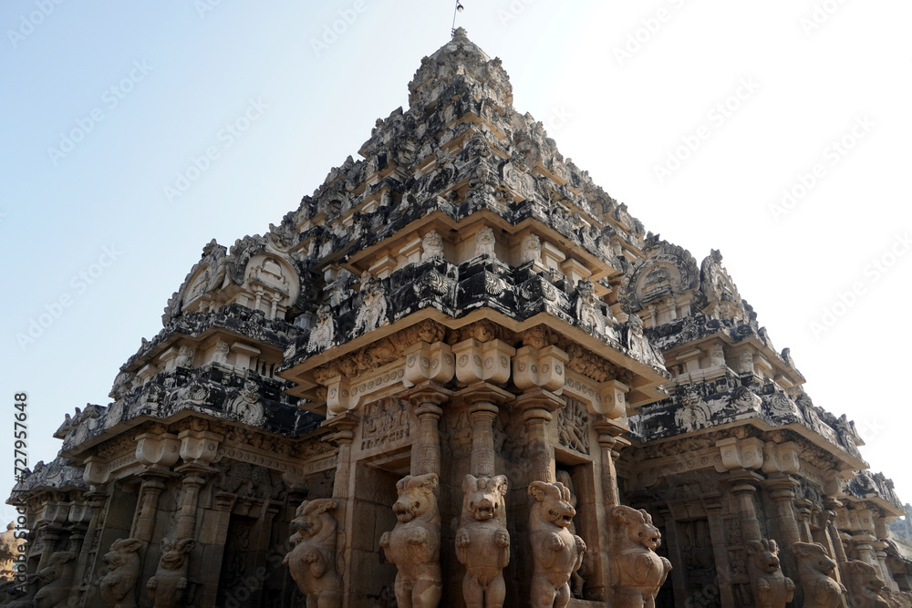 Gopuram of ancient temple against sky. Tall Tower with Sandstone carved God and Lion sculptures at historic Kanchi Kailasanathar temple in Kanchipuram, Tamilnadu.