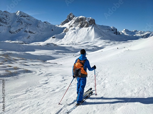 Ski mountaineer runs through a beautifully snowy mountain landscape in Glarus Schwyz. Ski tour on the Pfannenstock. Ski mountaineering in the Swiss Alps. Ski touring in winter. High quality photo