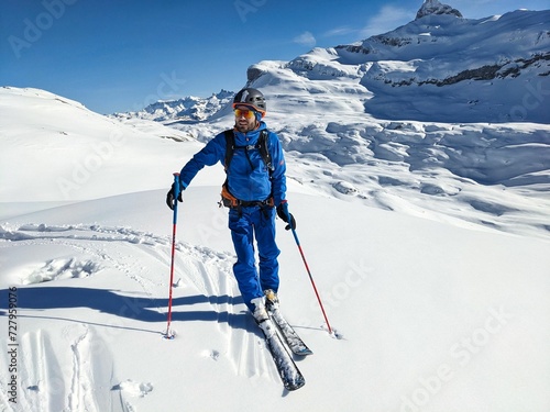 Younger climbs up the mountain on skis. Ski tourer climbs a large mountain in winter. Ski mountaineering in Braunwald Glarus. High quality photo