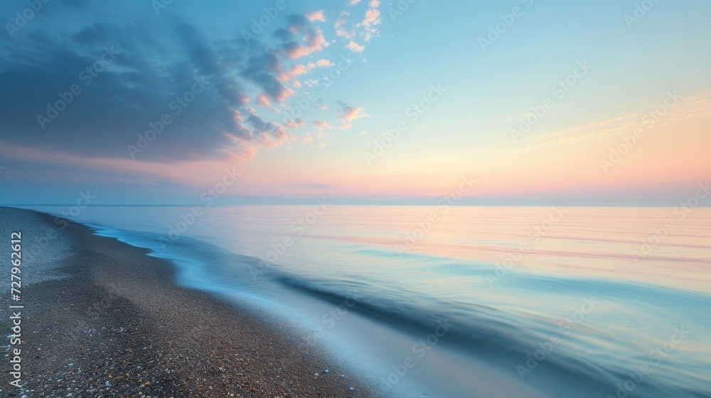 Tranquil beach sunrise with soft pastel colors in the sky and calm sea