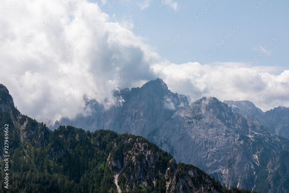 Scenic view of mountain peak Jof Fuart in untamed Julian Alps seen from summit Cima del Cacciatore, Monte Santo di Lussari, Friuli-Venezia Giulia, Italy. Wanderlust in remote Italian Alps in summer Scenic view of mountain peak Jof Fuart in untamed Julian Alps seen from summit Cima del Cacciatore, Monte Santo di Lussari, Friuli-Venezia Giulia, Italy. Wanderlust in remote Italian Alps in summer