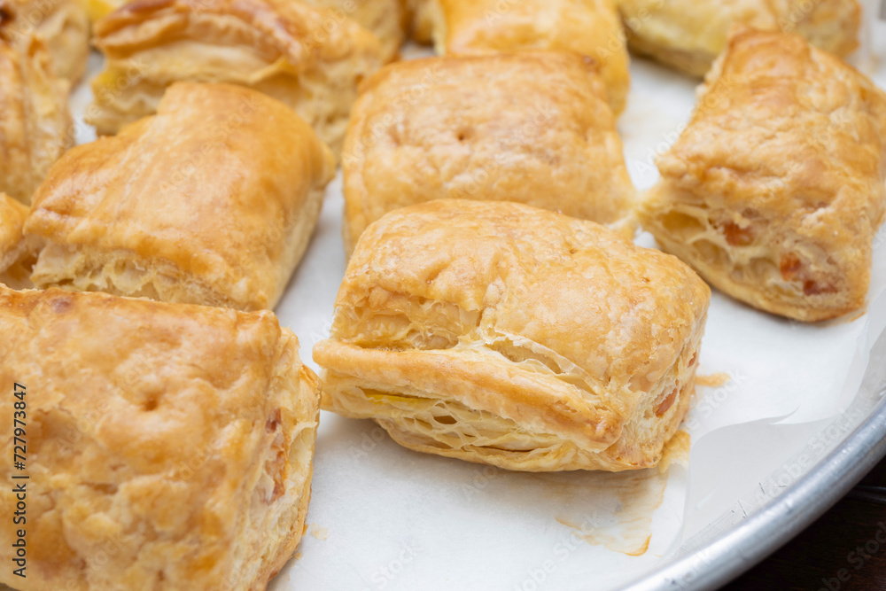 freshly baked puff pastry squares with cheese in tray freshly baked puff pastry squares with cheese in tray