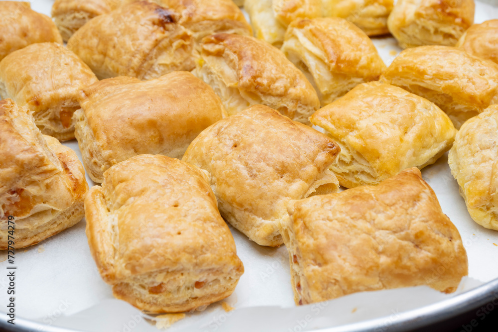 freshly baked puff pastry squares with cheese in tray freshly baked puff pastry squares with cheese in tray