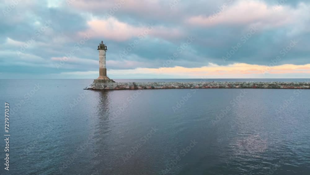 Inactive lighthouse on stone pier breakwater. Clouds at sunset. Lake Ladoga, Russia. 4K. Inactive lighthouse on stone pier breakwater. Clouds at sunset. Lake Ladoga, Russia. 4K.