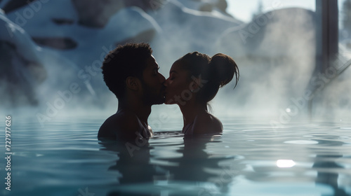 Couple kissing in an outdoor hot tub pool, snowy landscape