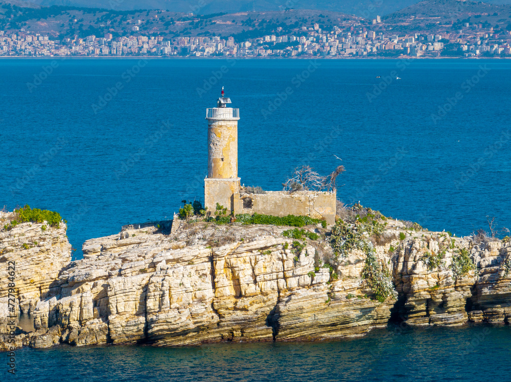 View of Peristeres Kaparelli Light lighthouse beacon on an island in the Ionian sea, Greece, seen from Kassiopi village, Corfu Island, with Albania in the background, summer sunny day