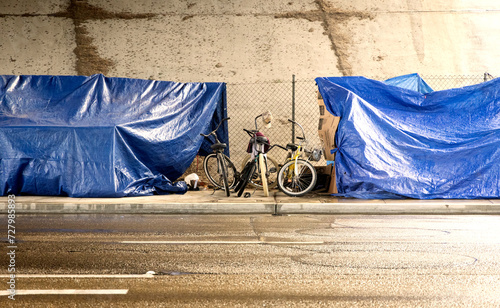 A homeless camp with bikes under a bridge during a rain storm 001 photo