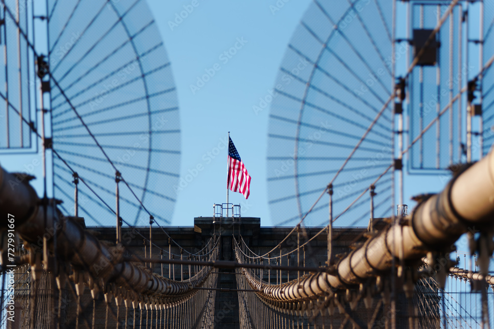 Obraz premium Drapeau américain sur un pilier du Brooklyn bridge reliant Brooklyn à Manhattan