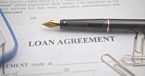 Business loan agreement or legal document concept : Fountain pen on a loan agreement paper form. Loan agreement is a contract between a borrower and a lender, a compilation of various mutual promises.