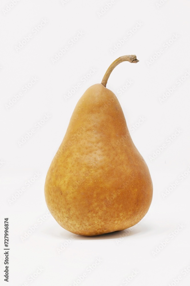 A single, ripe bosc pear on a white background in portrait orientation A single, ripe bosc pear on a white background in portrait orientation