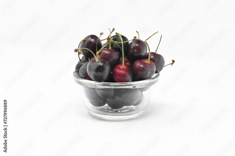 A bowl full of cherries red and delicious on a white background A bowl full of cherries red and delicious on a white background