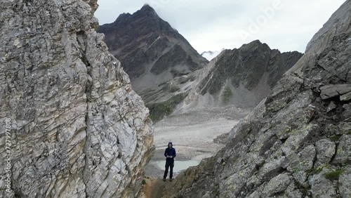 Drone flight through col Johannesscharte (Forcella Giovanni) with male hiker (man) controlling the drone towards mountain panorama in Texel group, South Tyrol, Italy photo