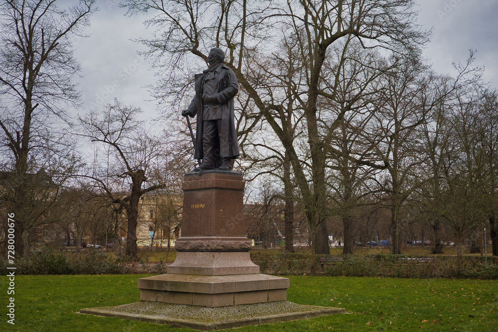 Obraz premium Ganzkörperansicht des Karl-Heine-Denkmals an der Klingerbrücke, Bronzestatue auf Steinsockel in einer Parkanlage, Leipzig, Sachsen, Deutschland