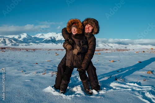 Happy father and child having fun on mountains background in winter
