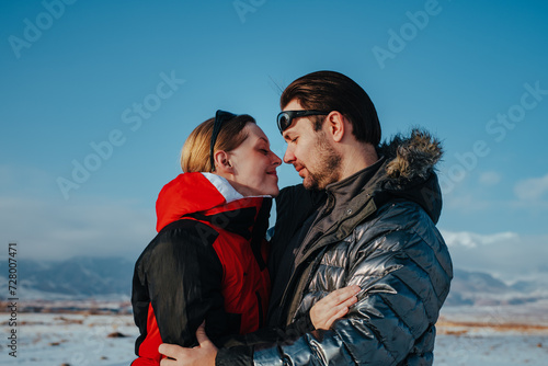 Romantic young couple embracing on mountains background in winter