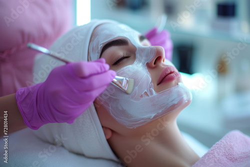 Cosmetologist applies a face mask to a woman in a spa studio