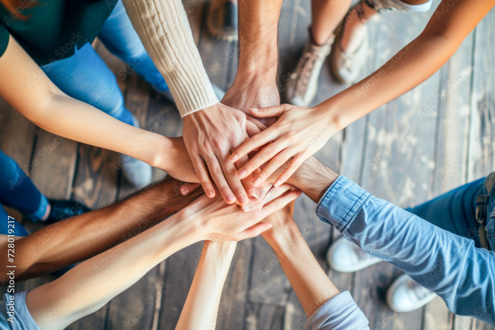 A top-down view of a group of friends stacking their hands together, symbolizing unity, A top-down view of a group of friends stacking their hands together, symbolizing unity,