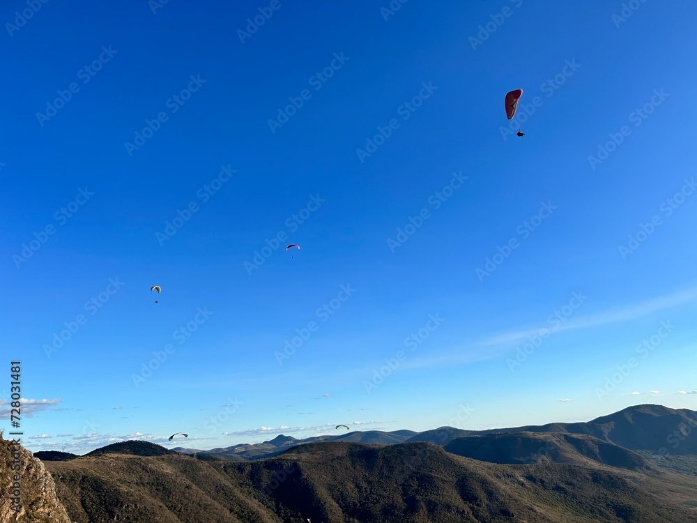 PHOTOGRAPH OF PARAGLIDERS FLYING FROM THE CHALCHIHUAPAN HILL, PUEBLA, MEXICO