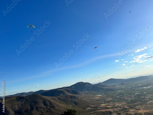 PHOTOGRAPH OF PARAGLIDERS FLYING FROM THE CHALCHIHUAPAN HILL, PUEBLA, MEXICO