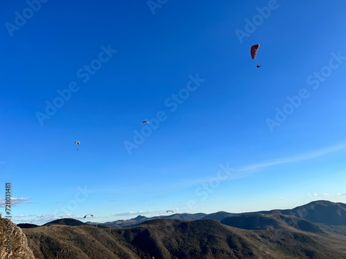 PHOTOGRAPH OF PARAGLIDERS FLYING FROM THE CHALCHIHUAPAN HILL, PUEBLA, MEXICO