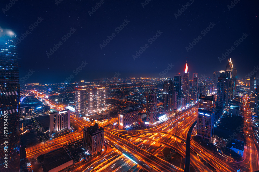 Aerial top view night cityscape of Dubai downtown skyscrapers with illuminated and highway. Business and financial modern district of city UAE